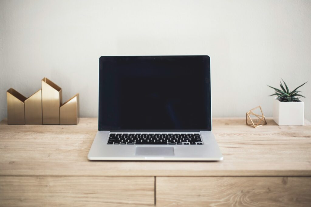 MacBook Pro on top of brown table
desk